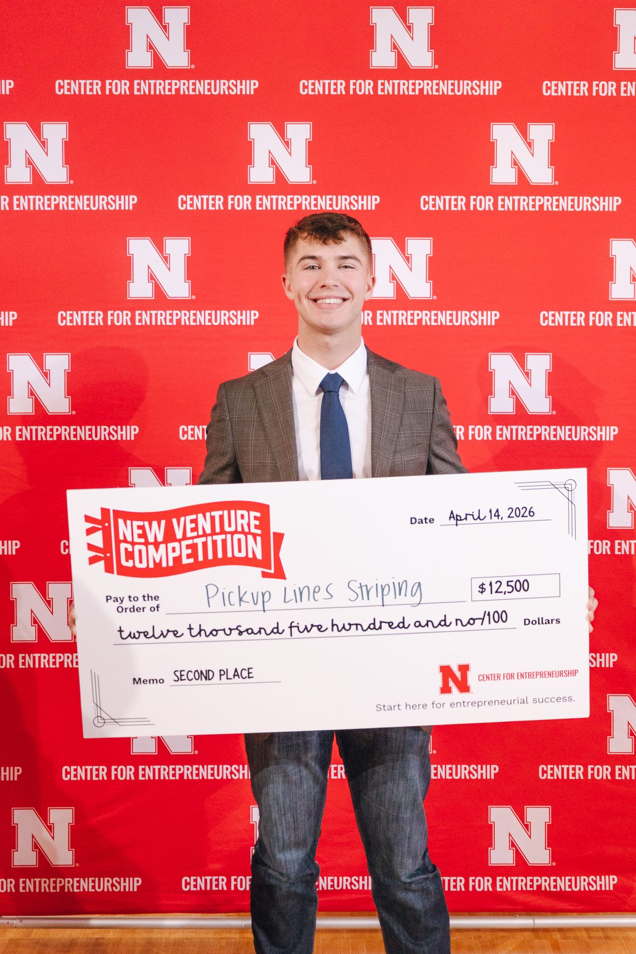 Karter Otte holding a second-place check at the University of Nebraska New Venture Competition