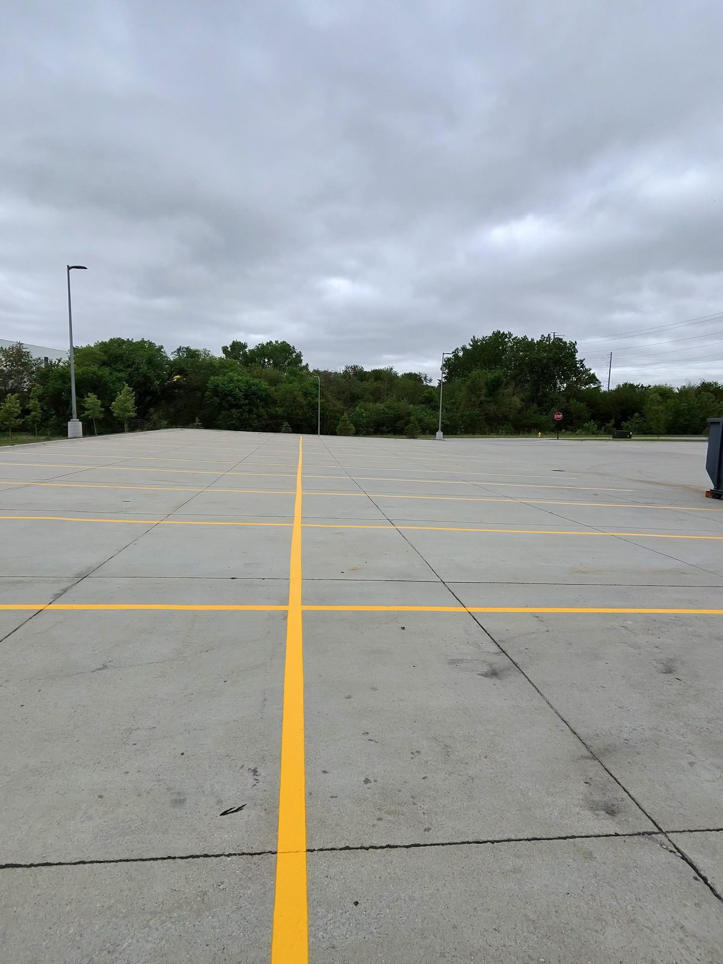 Freshly striped yellow lines on a large concrete parking lot